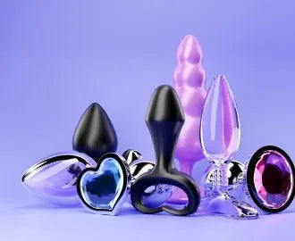 Butt plugs and Anal beads in various colours on a purple background